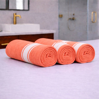 Zaruva bamboo cotton towel set of 3 (orange) rolled towels on bathroom counter, quick-dry flat weave look