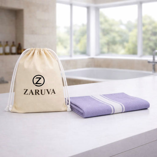 zv-pack=set-of-1 | ZARUVA pouch beside a folded lavender bamboo bath towel with white stripe border on a modern bathroom counter