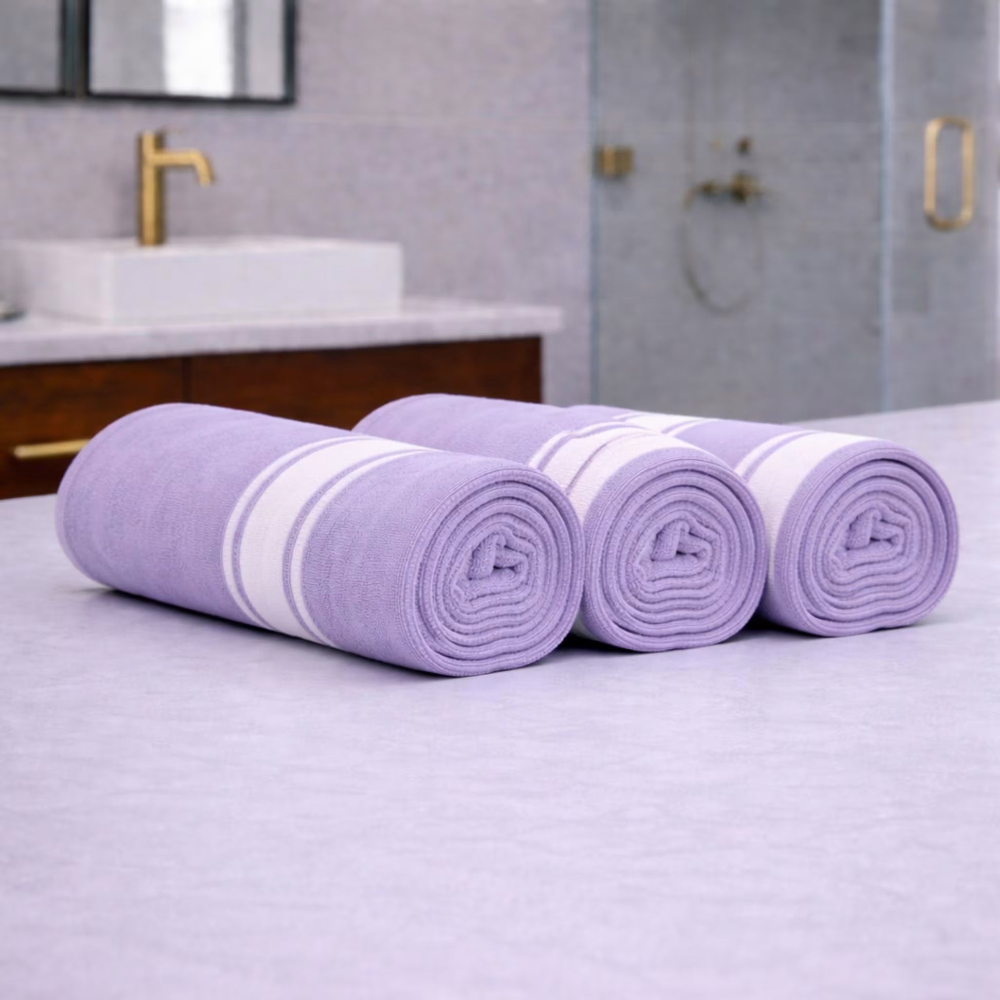 Rolled lilac purple bamboo towel with a white stripe band placed on a bathroom countertop, close up texture and neat roll
