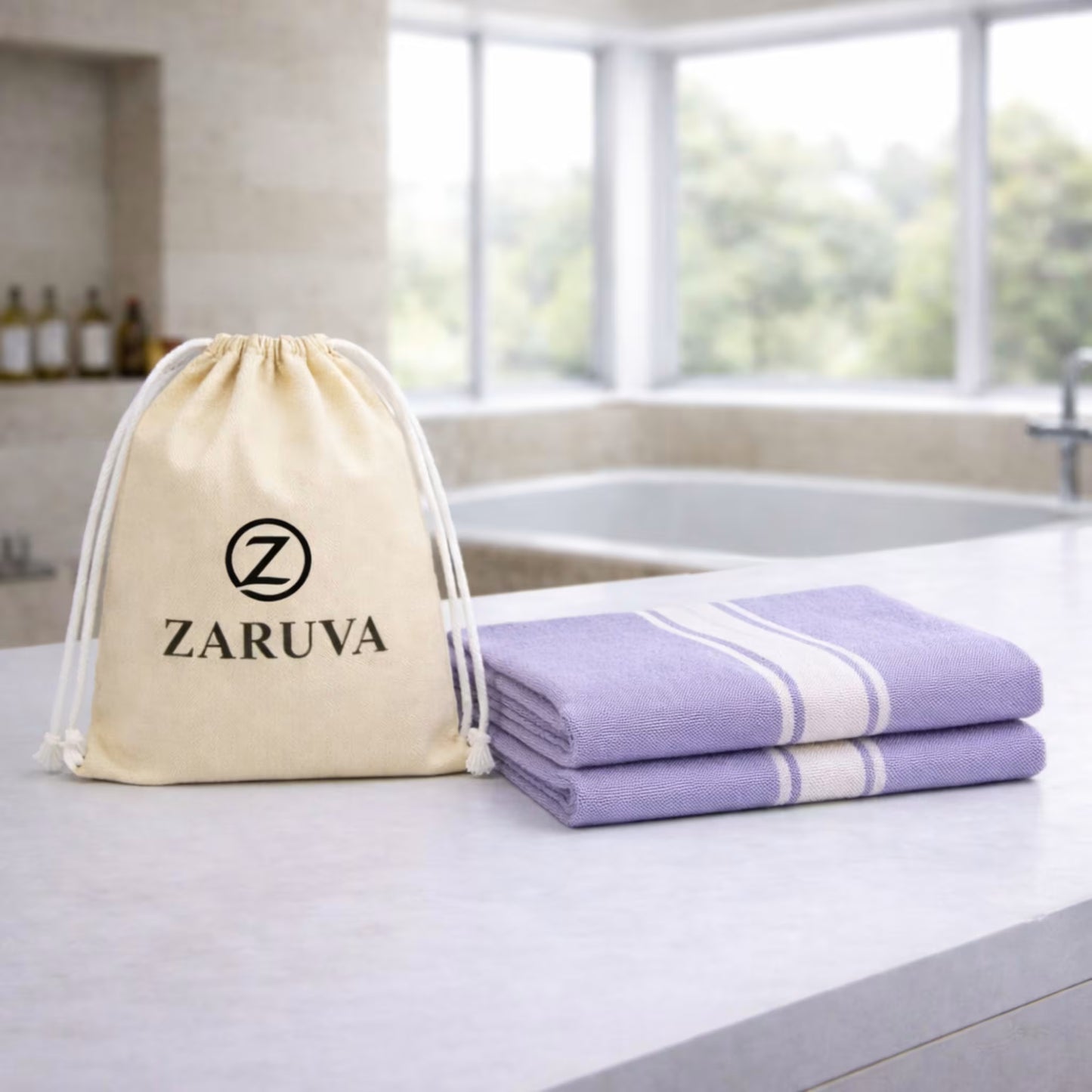 Purple bamboo bath towel set of 2 with Zaruva drawstring pouch on a modern bathroom countertop